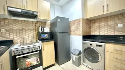 a kitchen with a refrigerator and a dishwasher at Modern 1BR Retreat with Balcony in Vibrant JVC by Bhavan Vacation Homes in Dubai