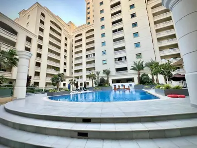 a large building with a pool in front of it at Modern 1BR Retreat with Balcony in Vibrant JVC by Bhavan Vacation Homes in Dubai