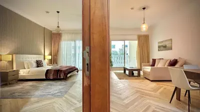 a hotel room with a bed and a living room at Modern 1BR Retreat with Balcony in Vibrant JVC by Bhavan Vacation Homes in Dubai