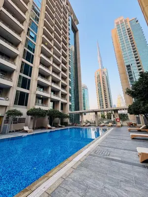 a swimming pool in the middle of a city with tall buildings at Burj KhalifaView Luxury 1-Bedroom Apartment in Dubai