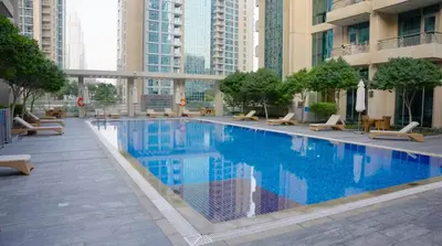 a large swimming pool in a building with buildings at Burj KhalifaView Luxury 1-Bedroom Apartment in Dubai