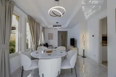 a white living room with a table and chairs at Family Friendly - 2BR & Maid's Room in The Springs 10 - Allsopp & Allsopp in Dubai