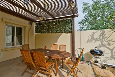 a patio with a table and chairs and a grill at Family Friendly - 2BR & Maid's Room in The Springs 10 - Allsopp & Allsopp in Dubai