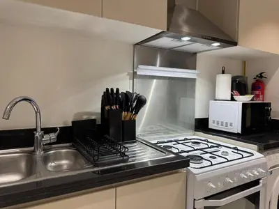 a kitchen with a stove top and a sink at ASHRI Studio in Carson C, Damac Hills 1 in Dubai