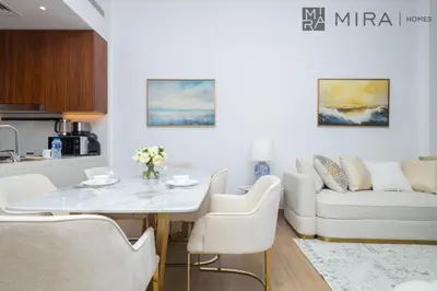 a kitchen and living room with a white table and chairs at Mira Holiday Homes - Newly 2 bedroom in La Sirene, Port De La Mer in Dubai
