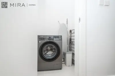 a washing machine in a laundry room with a surfboard at Mira Holiday Homes - Newly 2 bedroom in La Sirene, Port De La Mer in Dubai