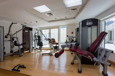 a gym with several treadmills and exercise machines at Signature Studio JLT in Dubai