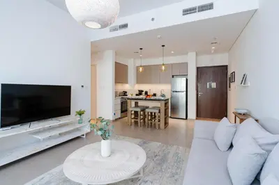 a living room with a white couch and a table at Comfortable Stylish Haven - Great Community in Dubai