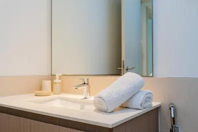 a bathroom sink with a towel on it at Comfortable Stylish Haven - Great Community in Dubai
