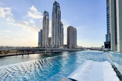 a pool in the middle of a city with tall buildings at SIMPLY COMFORT in Missoni Top Floor with Sea, Canal and Burj Khalifa Views in Dubai
