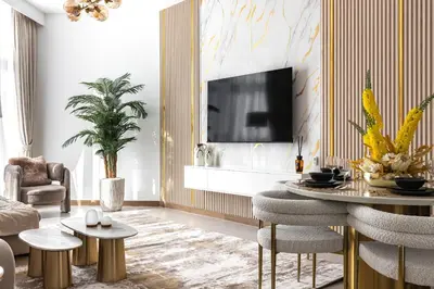 a living room with a tv and a table and chairs at SIMPLY COMFORT in Missoni Top Floor with Sea, Canal and Burj Khalifa Views in Dubai