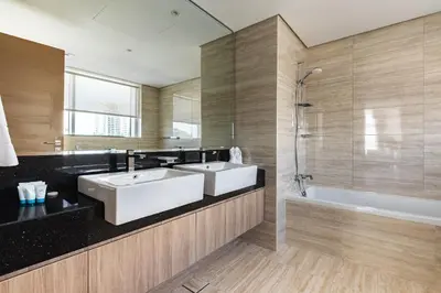 a bathroom with two sinks and a bath tub at SIMPLY COMFORT in Missoni Top Floor with Sea, Canal and Burj Khalifa Views in Dubai