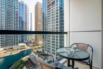 a table on a balcony with a view of a city at GuestReady - Magnificent stay with lake view in Dubai