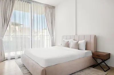 a bedroom with a large bed and a large window at Stunning 1 br modern luxury residence at JVC in Dubai