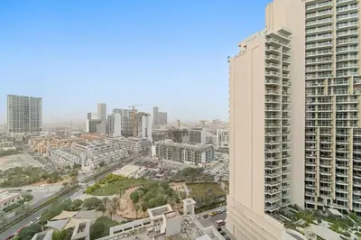 a view of a city with a tall building at Chic JVC Studio in Dubai - Pool, Gym, Free Parking, City Views & Prime Location in Dubai