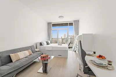 a living room with a couch and a bed at Chic JVC Studio in Dubai - Pool, Gym, Free Parking, City Views & Prime Location in Dubai