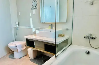 a bathroom with a sink and a toilet and a tub at Vserve Stylish Suite 1 BR with Burj Khalifa and Canal view in Dubai