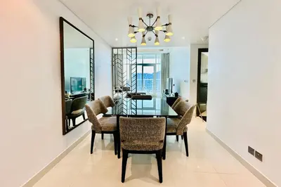 a dining room with a glass table and chairs at Vserve Stylish Suite 1 BR with Burj Khalifa and Canal view in Dubai