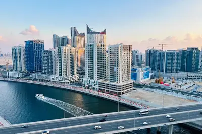 a city with a bridge over a river with buildings at Vserve Stylish Suite 1 BR with Burj Khalifa and Canal view in Dubai
