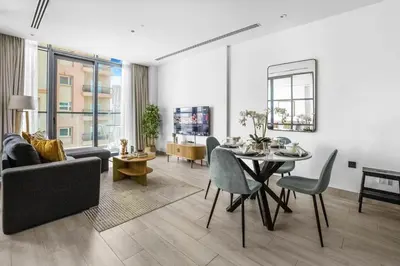 a living room with a table and a dining room at Comfy 1BR w Cinema Room Business Centre Pool Table and Sauna in Dubai