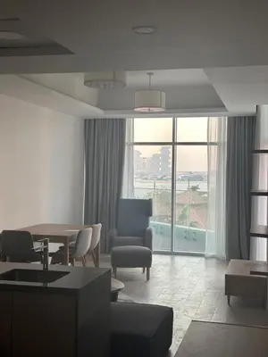 a living room with a table and chairs and a large window at Azizi Mina in Dubai
