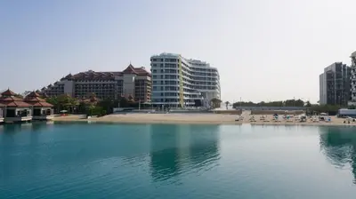 a body of water with a beach and buildings at Azizi Mina in Dubai