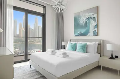 a bedroom with a large white bed and a large window at Silkhaus Seaside 2BDR in Marina Vista Beachfront in Dubai