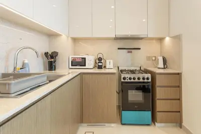 a kitchen with a stove and a microwave at Prime Downtown Location 2BR Apt Burj Royale in Dubai