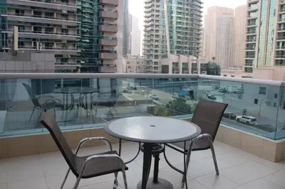 a table and chairs on a balcony with a view of a city at One bed apartment at a great location in Dubai Marina in Dubai