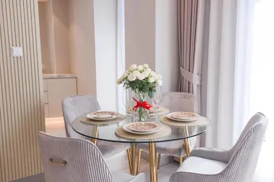 a dining room table with chairs and a vase of flowers at Stunning 1BR in heart of Dubai Marina in Dubai