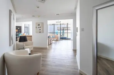 a living room with white furniture and a dining room at Frank Porter - 23 Marina in Dubai