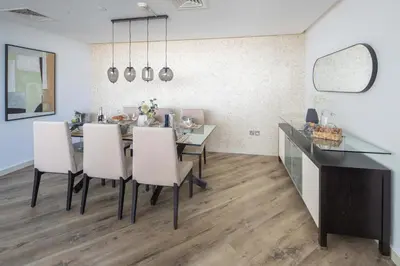 a dining room with a table and white chairs at Frank Porter - 23 Marina in Dubai