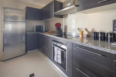 a kitchen with gray cabinets and stainless steel appliances at Frank Porter - 23 Marina in Dubai