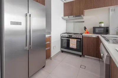 a kitchen with a stainless steel refrigerator and a sink at Frank Porter - Park Gate in Dubai