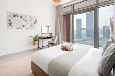 a bedroom with a bed and a desk and a window at Frank Porter - Park Gate in Dubai