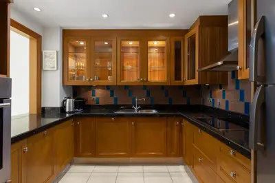 a kitchen with wooden cabinets and a sink at Maison Privee - Stylish & Spacious Apartment in Downtown Dubai in Dubai