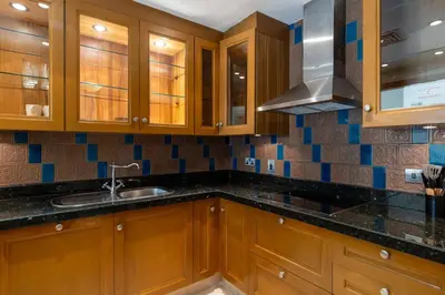 a kitchen with wooden cabinets and a sink at Maison Privee - Stylish & Spacious Apartment in Downtown Dubai in Dubai
