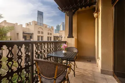a patio with a table and chairs on a balcony at Maison Privee - Stylish & Spacious Apartment in Downtown Dubai in Dubai