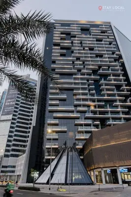 a tall building with a palm tree in front of it at Experience Iconic Burj Khalifa Views from Your Cozy Getaway with Pool in Dubai