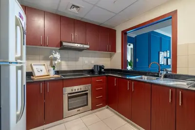 a kitchen with brown cabinets and a sink and a refrigerator at GuestReady - Serene Dubai Marina haven in Dubai