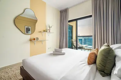 a bedroom with a large white bed with a large window at GuestReady - Serene Dubai Marina haven in Dubai