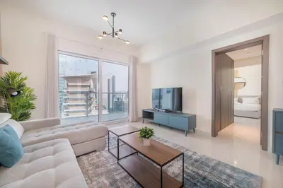 a living room with a couch and a tv at Elegant 1BR with Balcony & Views in Business Bay in Dubai