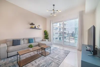 a living room with a couch and a large window at Elegant 1BR with Balcony & Views in Business Bay in Dubai