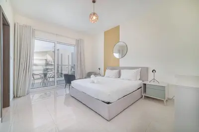 a white bedroom with a bed and a balcony at Elegant 1BR with Balcony & Views in Business Bay in Dubai