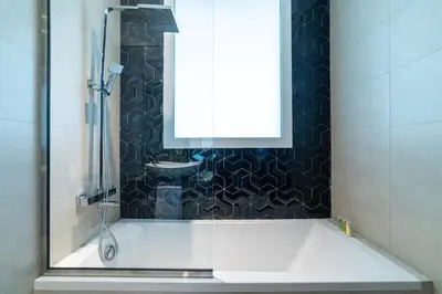 a bathroom with a tub with a window and a sink at Elegant 1BR with Balcony & Views in Business Bay in Dubai