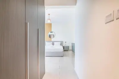 a bedroom with a white bed in a room at Luxurious 1-BR with Balcony & Views Business Bay in Dubai