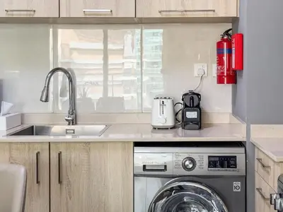 a kitchen with a sink and a washing machine at Luxurious 1-BR with Balcony & Views Business Bay in Dubai