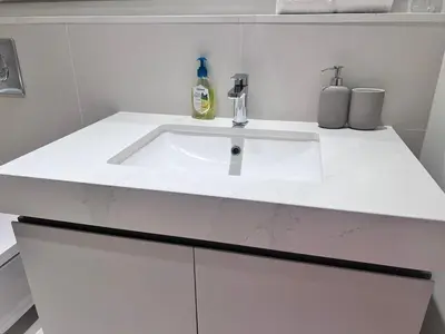 a white bathroom sink with a bottle of soap at A Luxurious 2 Bedroom Emaar Beachfront Apartment in Palm Jumeirah in Dubai