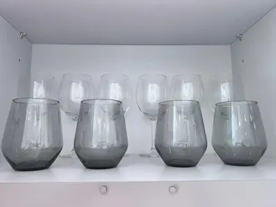 a row of wine glasses sitting on a shelf at A Luxurious 2 Bedroom Emaar Beachfront Apartment in Palm Jumeirah in Dubai