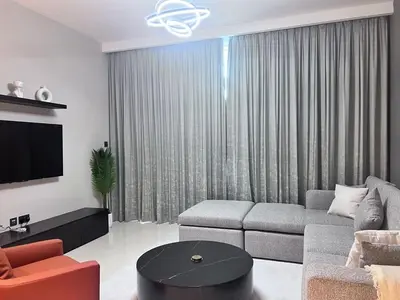 a living room with a couch and a tv at A Luxurious 2 Bedroom Emaar Beachfront Apartment in Palm Jumeirah in Dubai